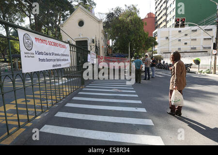 Sao Paulo, Brasile. 23 Luglio, 2014. Una donna si erge davanti alla porta chiusa della filantropia ospedale Santa Casa di Sao Paulo, Brasile, il 23 luglio 2014. La Santa Casa Ospedale, il più grande ospedale filantropiche in America Latina, interrompe l urgenza e il servizio di emergenza da martedì notte a causa della mancanza di denaro per acquistare farmaci e materiali. © Rahel Patrasso/Xinhua/Alamy Live News Foto Stock