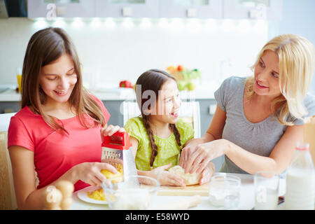 Ritratto di felice femmine rendendo l'impasto e preparazione di ingredienti per pizza Foto Stock