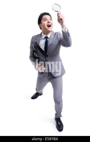 Imprenditore con lente di ingrandimento Foto Stock
