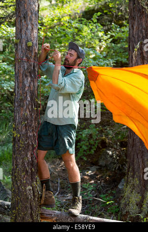 Backpacker impostazione di un telo a sua camp nel Wallowa Mountains, Oregon. Foto Stock