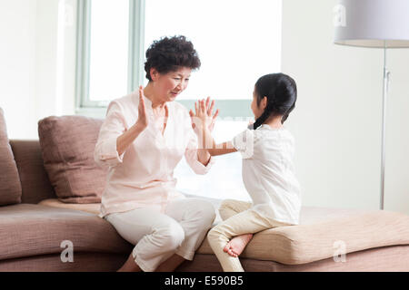 Felice la nonna e la nipote giocando battimani gioco Foto Stock