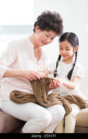 Felice la nonna e la nipote della maglieria in salotto Foto Stock