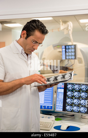 Medico maschio esame MRI scan rapporto medico in camera di scansione Foto Stock
