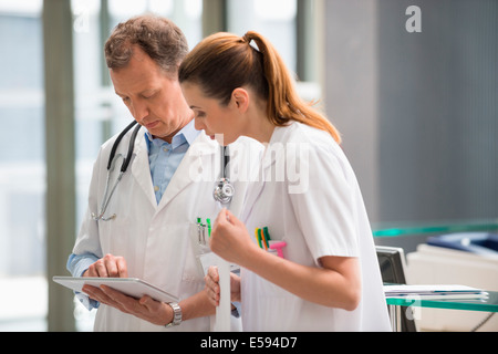Due medici analisi Relazione medica sulla tavoletta digitale in ospedale Foto Stock