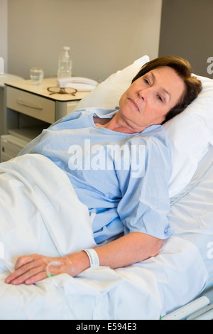 Donna sdraiata nel letto di ospedale Foto Stock