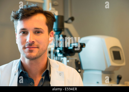 Ritratto di medico maschio con occhio dell'apparecchiatura di prova Foto Stock