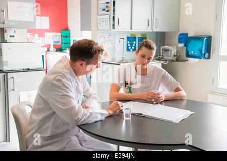 Medico e infermiere analizzando record medici in un ospedale Foto Stock