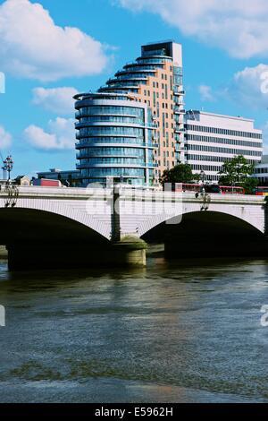 Il lato del sud di grado 2 elencati di Putney Bridge con il XXI secolo Putney Wharf Tower e iconico double decker bus London Inghilterra England Foto Stock