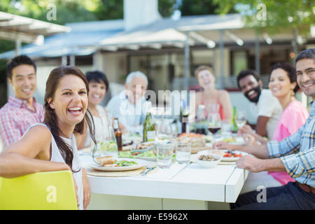 Amici sorridenti a tavola all'aperto Foto Stock