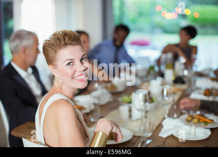 Donna sorridente al dinner party Foto Stock