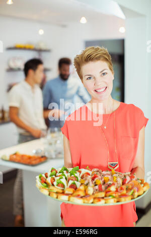 Donna che serve cibo a parte Foto Stock