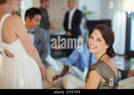 Donna sorridente sul divano a parte Foto Stock