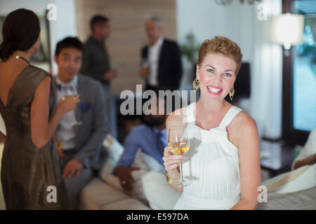 Donna sorridente sul divano a parte Foto Stock