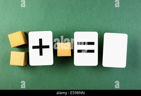 Cubo di legno e la tessera della scuola con problemi matematici Foto Stock