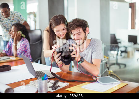 Persone revisione foto insieme in ufficio Foto Stock