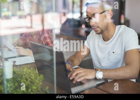 Uomo con notebook in cafe Foto Stock