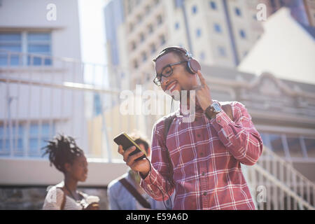 Uomo che ascolta mp3 player all'aperto Foto Stock