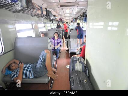 Jakarta, Indonesia. Il 24 luglio, 2014. Passeggeri prendono un treno per tornare al loro villaggio a Pasar Senen stazione ferroviaria di Jakarta, Indonesia, 24 luglio 2014. I musulmani in Indonesia si muovono dalle città importanti per la loro città di appartenenza per celebrare la musulmana di Eid al-Fitr festival in luglio 28 e 29, che segna la fine del mese di digiuno del Ramadan. © Agung Kuncahya B./Xinhua/Alamy Live News Foto Stock