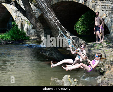 Il Tamigi a Wolvercote, Oxford, Oxfordshire, Regno Unito. Il 24 luglio, 2014. Il raffreddamento nel Tamigi a Wolvercote nel tempo caldo, Oxford, Oxfordshire.UK. Sam Robertson 10, e sua sorella Jessica 9, guardato dal loro papà Craig Credito: Denis Kennedy/Alamy Live News Foto Stock