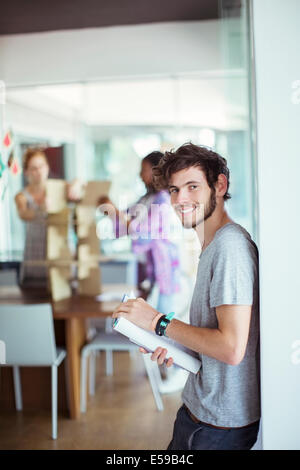 Uomo che porta libro in ufficio Foto Stock