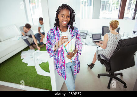 Donna di bere il caffè in ufficio Foto Stock