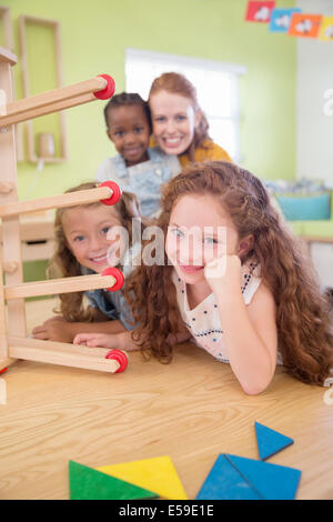 Gli studenti e il maestro sorridente in aula Foto Stock