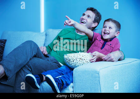 Padre e figlio di guardare la televisione in salotto Foto Stock