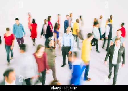 Imprenditore in piedi tra la folla vivace Foto Stock