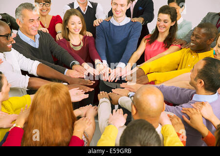 La gente di affari con le braccia aperte in huddle Foto Stock