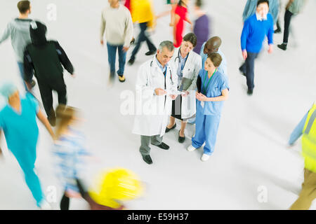 Vivace folla intorno a medici e infermieri Foto Stock