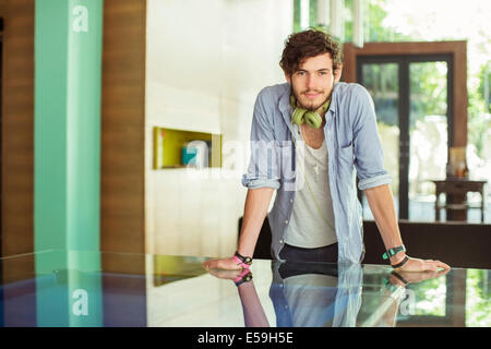 Uomo appoggiato sulla scrivania in ufficio Foto Stock