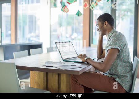 Uomo al lavoro su computer portatile in ufficio Foto Stock