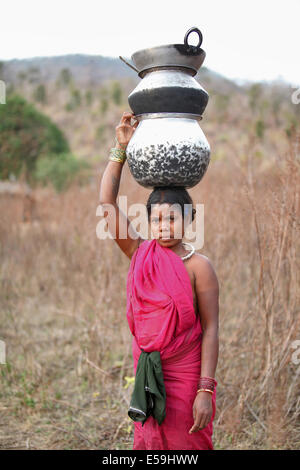 Donna tribale che porta utensili sulla sua testa, Kamar tribù, Matal Village, Chattisgadh, India Foto Stock