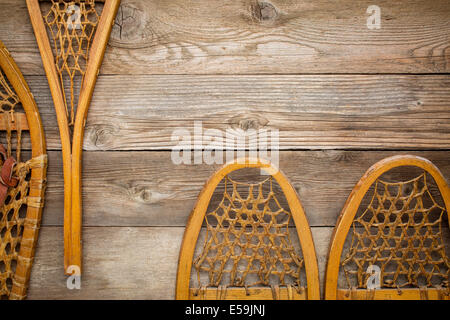 Vintage Huron e Bear Paw racchette da neve contro la grana tavole di legno con una copia spazio Foto Stock