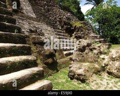 Un volto scolpito alla base del Tempio elevato a Lamanai in Belize Foto Stock
