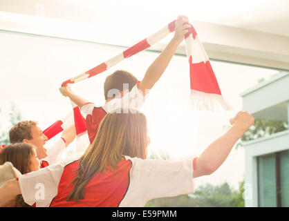 Famiglia nelle maglie dello sport il tifo nel soggiorno Foto Stock