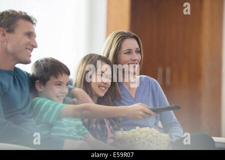 Famiglia di guardare la televisione in salotto Foto Stock