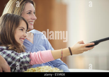 Madre e figlia di guardare la televisione in salotto Foto Stock