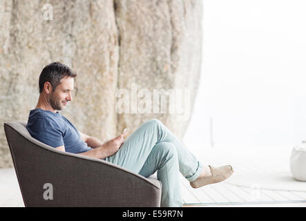 Uomo seduto in poltrona moderna Foto Stock