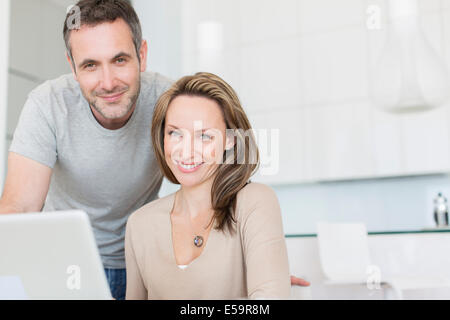 Coppia sorridente al laptop Foto Stock