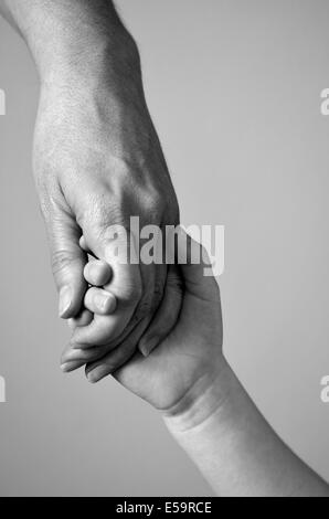 Adulto o il genitore tiene per mano un bambino piccolo Foto Stock