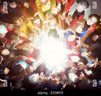 Folla variegata raggiungendo per la brillante luce Foto Stock