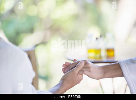 Matura in accappatoi tenendo le mani in spa Foto Stock