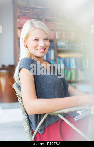 Donna sorridente in poltrona Foto Stock