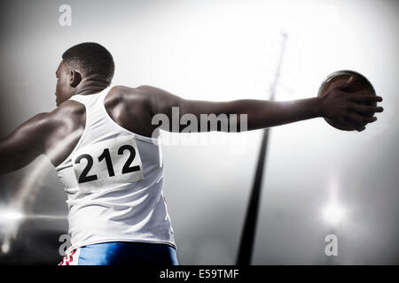 La via e il campo atleta gettando discus Foto Stock