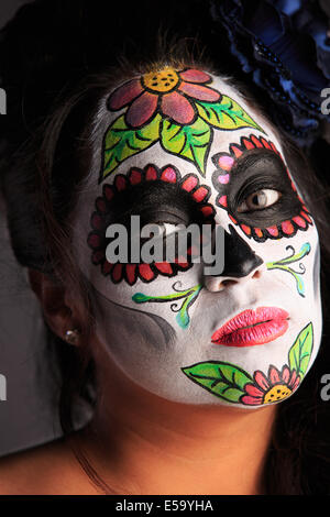 Una giovane donna con vernice faccia a forma di teschio di zucchero decorato per il Dia de los Muertos Foto Stock