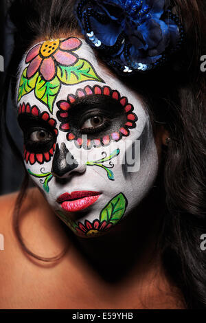 Una giovane donna con vernice faccia a forma di teschio di zucchero decorato per il Dia de los Muertos Foto Stock