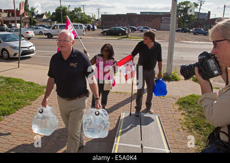 Detroit, Michigan STATI UNITI D'AMERICA - Una delegazione del Canada acqua erogata a Detroit come una protesta contro la città di shutoffs d'acqua. Come si tenta di recuperare dal fallimento, la città è intercettazione acqua a decine di migliaia di persone che vivono in condizioni di povertà che sono dietro a loro fatture. Paolo umido, presidente nazionale dell Unione Canadese di dipendenti pubblici, porta acqua al San Pietro Chiesa Episcopale, uno dei siti di attivisti hanno istituito in cui i residenti possono andare a prelevare acqua se il loro servizio è stato spento. Foto Stock