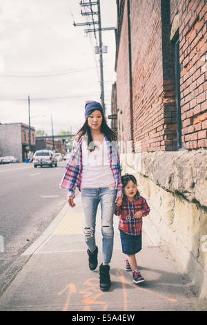 Il coreano madre e figlia tenendo le mani su una strada di città Foto Stock