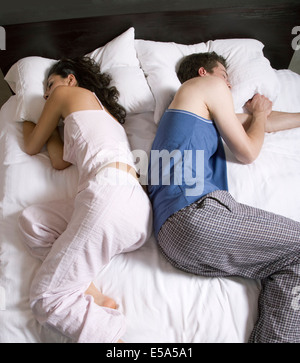 Giovane sleeping back-to-back sul letto Foto Stock